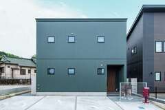 オリーブグリーン、カーキなどの色が好きというご主人の希望を尊重した、ガルバリウムの外壁。開口部を最小限にした正面は端正な表情【アフターホーム】