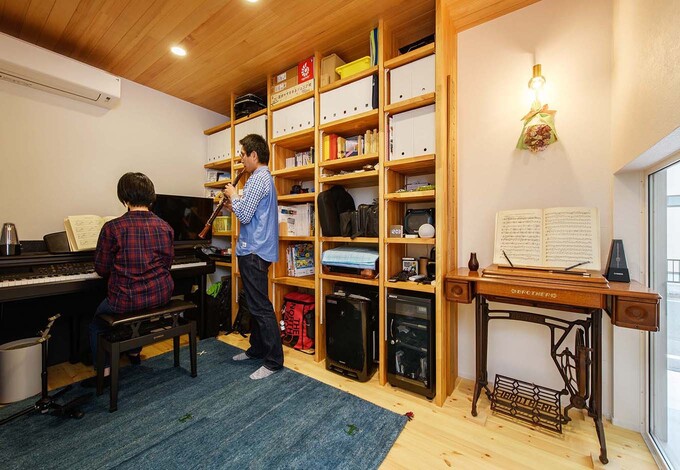 家族みんなで楽器演奏を楽しむ音楽ルーム。壁に設けた造作の収納棚は、音楽関係の本や機材もひとまとめにしまっておける大きさ