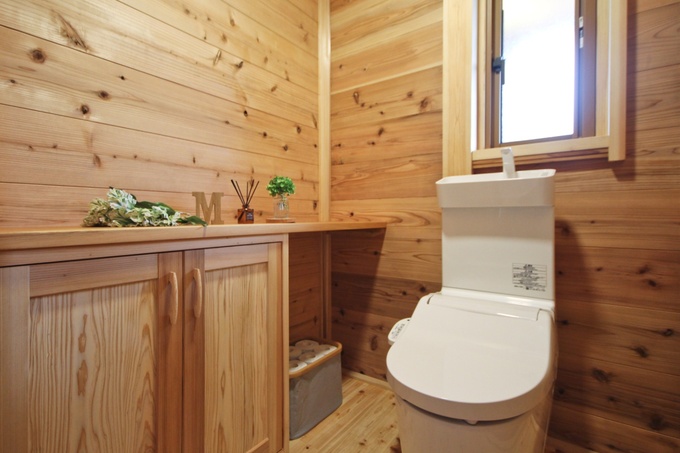 木の温もりを感じるトイレ空間で、ナチュラルな雰囲気が魅力。窓からの自然光が心地よく、収納も充実。リラックスできる空間になっている。