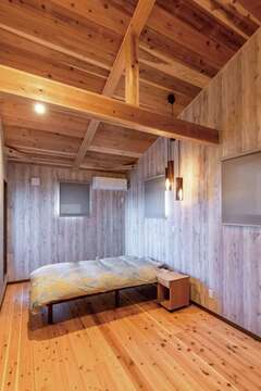 勾配天井の寝室は山小屋のような大らかさ。ウォークインも用意【片山建設】