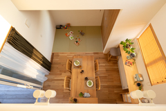 ダイニングスペースは木製のテーブルと椅子を配置し、明るい窓からの自然光が心地よい。隣には畳スペースも見える。