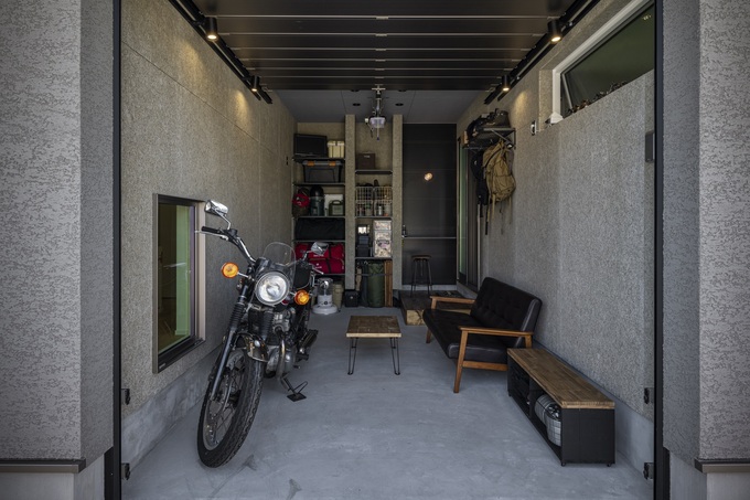 秘密基地②インナーガレージ。旦那様こだわりのこの空間ではバイクのお手入れやDIYをされている。キャンプ道具や工具など収納力もあるガレージ。