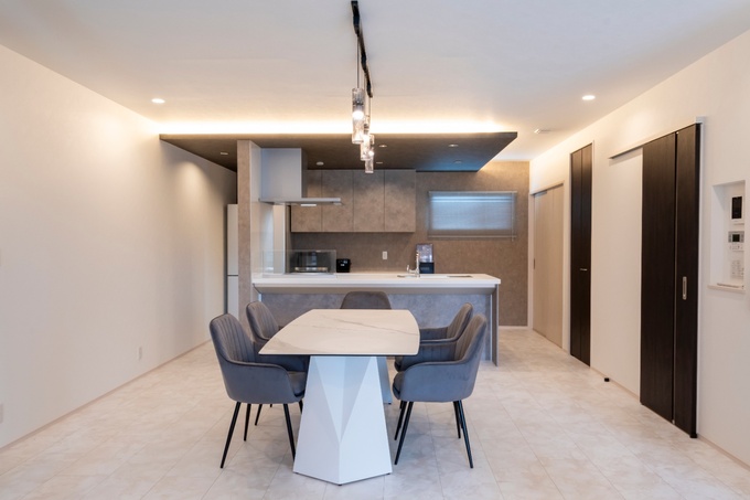 モダンなデザインのLDKで落ち着いた雰囲気を演出。広々とした空間に、ダイニングセットとキッチンが自然に調和している。