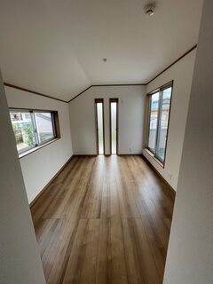 窓から差し込む自然光が心地よい居室の一角。落ち着いた床材とシンプルな壁面が空間に広がりを与えている【タムラ建築設計】