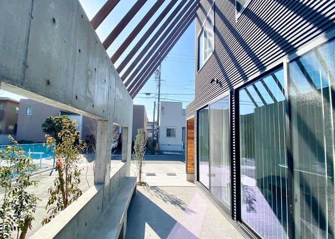 コンクリートの壁にベンチを造作してくつろげる場に。窓を開ければ、内と外ががひとつにつながる