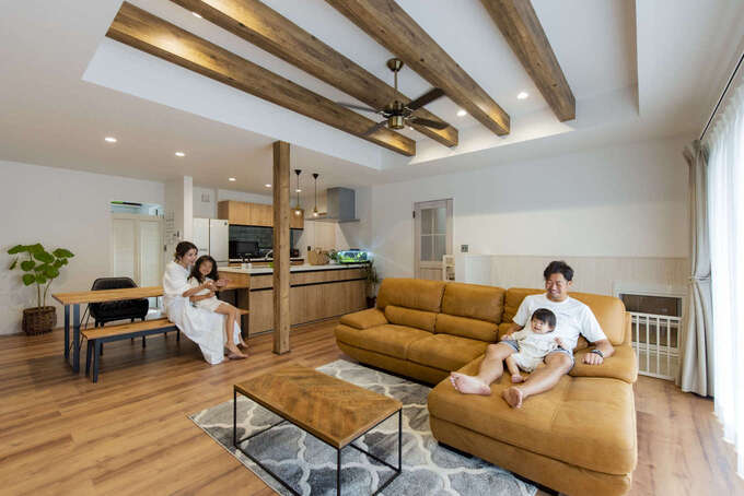 家にいながらリゾートのような非日常を感じる子世帯のLDK。梁見せの折上げ天井を採用したことでより開放感が生まれた。フローリングの色と質感に合わせた家具のセレクトもすてき