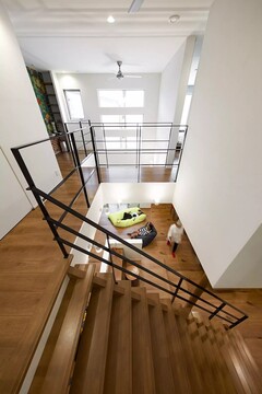 アイアンの手すりで、壁をつくらず目線が抜けるように。廊下のどこにいても、１階にいる家族の動きが目に入り、存在を感じられる心理的な安心を生み出すデザインにしました。