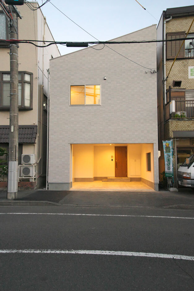 片流れの屋根が印象的な外観。限られた土地を有効活用するため、1階をガレージに。車は2台駐車可能