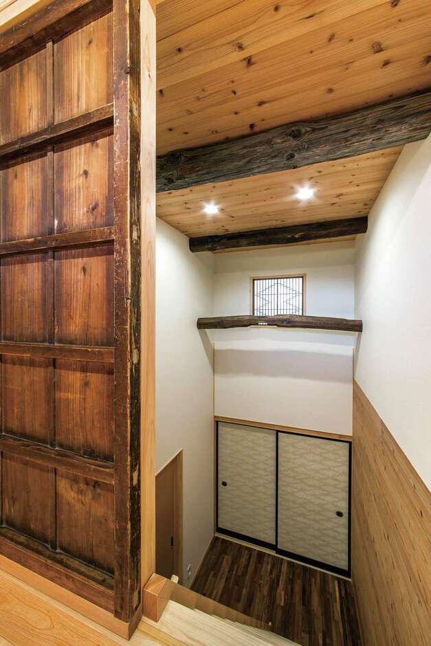 小屋裏に通じる吹き抜けのホールにも古い引き戸や古材を再利用
