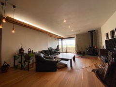 落ち着いた雰囲気のラウンジ。シックな黒のソファと心地よい薪ストーブが、快適な空間を演出している。