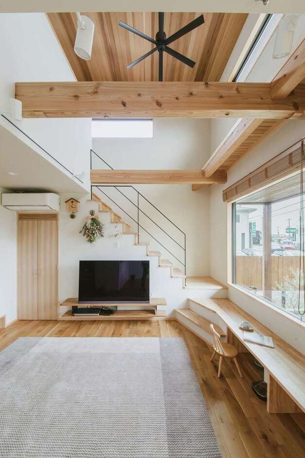 大らかな空間に天井に張られたスギがぬくもりをプラス。アクセントのアイアンやシーリングファンが引き締め、開放的でありながら落ち着く空間に仕上がった。デスク兼ベンチは家族にとって大切な場所に