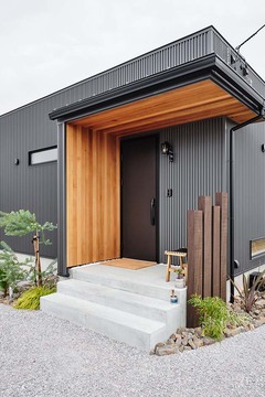 無垢のレッドシダーと植栽が、あたたかみを醸す玄関。視線をさりげなくカットする枕木フェンスにもセンスが光る【平屋建築ブルーハウス】