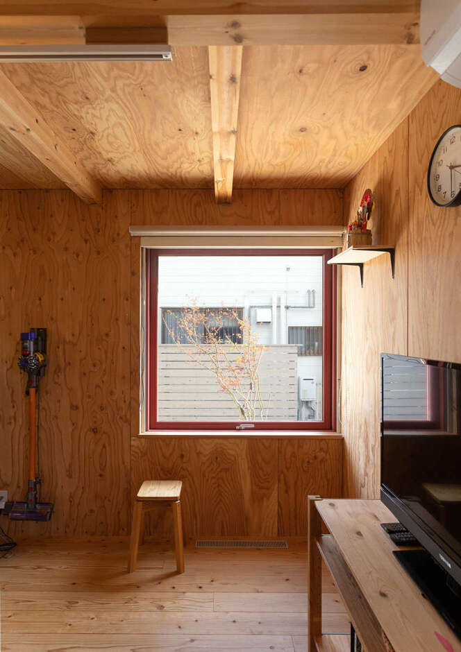 1階の開口部には赤い木製サッシを採用。断熱性も高く、意匠性にもすぐれているため、インテリア・アクセントとして木の空間を引き立てている。室内から庭の四季も楽しめる