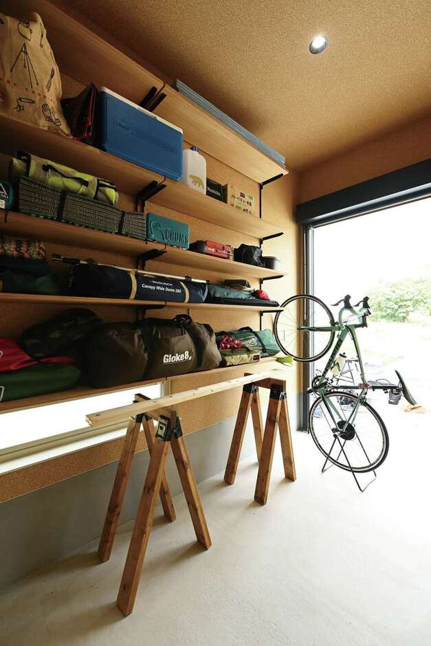 駐車場に面したインナーガレージは車用品やキャンプ道具など、趣味のギアを詰め込んだ、ご主人の宝箱。壁にはOSB合板風のクロスを用い、男前な空間に演出