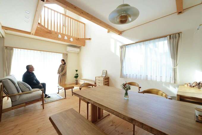 明るさと開放感に満たされた居心地のいいLDK。南北に長い敷地形状を考慮して、リビングに吹抜けと高窓を設け、十分な光を取り込めるよう設計されている。肌触りのいいフローリングは無垢のレッドパインで、経年変化も楽しめる