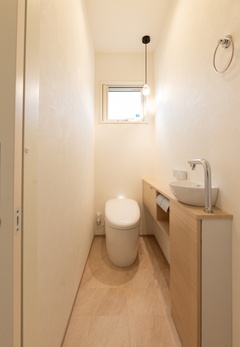 窓から自然光が差し込む明るいトイレスペース。シンプルながらも温かみのある配色が心地よい雰囲気を演出。コンパクトながら機能的な設計で快適。【オールハウジング】