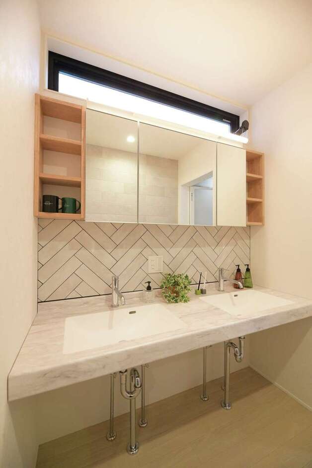 ホテルライクな洗面台。ヘリンボーン張りのタイルがアクセントに