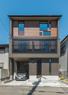 築30年の二階建てを壊し、木造三階建てに建て替えたM邸。3階の窓の形が独創的で、写真を撮っていく人もいるそう。2階の特注ルーバーが外観デザインのアクセントに。屋根に9kWのソーラーパネルを搭載し、毎月の光熱費をまかなっている【イシカワ】