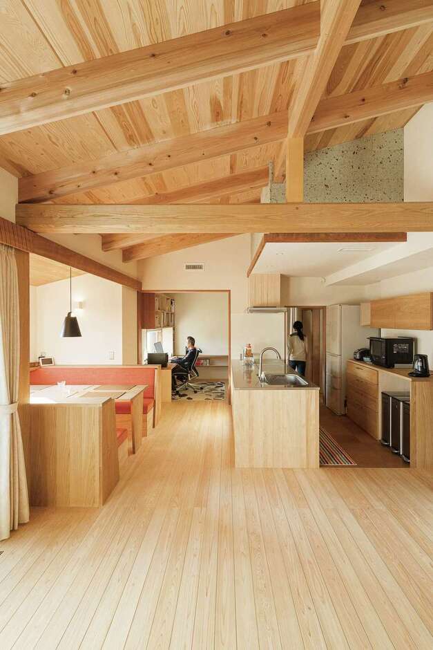 キッチンを中心に回遊できる20畳のLDK。東西に長くとり、勾配天井には『石牧建築』の代名詞でもある無垢の登り梁を採用