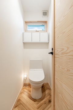 木のドアが、家全体の「木×白」をトイレにも。細部までデザインすることで世界観を大事にしています。【オレンジハウス】
