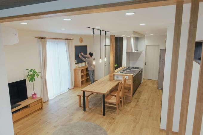 キッチンを囲むカウンターテーブルは同社からの贈り物。正面には子どもの学校道具をしまう造作収納と黒板ボードも設けた