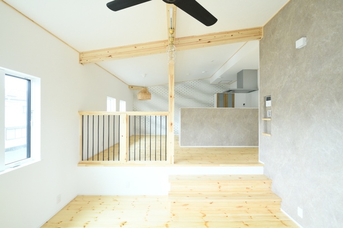 スキップフロアが特徴の室内空間である。木材を多用した温かみのあるデザインが心地よい。大きな窓から自然光が差し込む