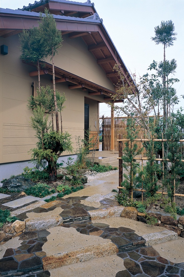 玄関アプローチには、台杉や竹垣などを配し、視線を導き露地風に。