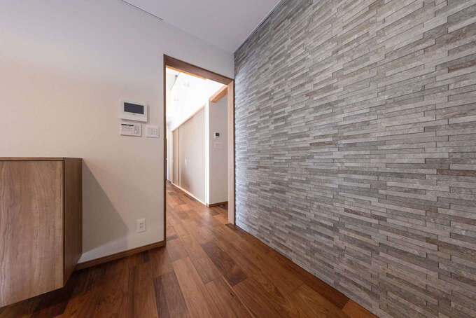 玄関奥の壁一面に調湿・消臭効果に優れたエコカラットを張って高級感を出した