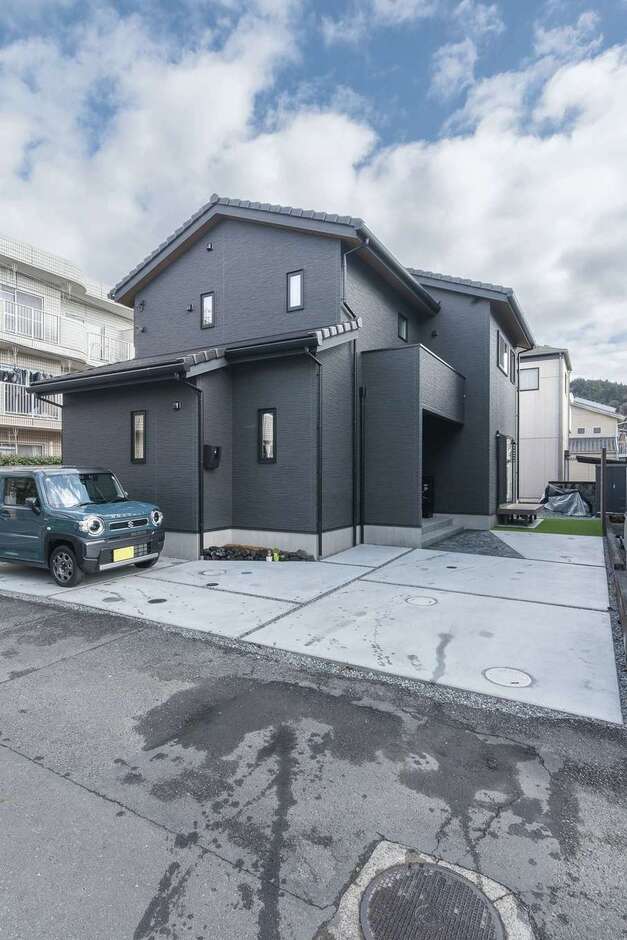 陶器瓦の外観は、外構にもひと工夫。玄関ポーチの前だけ石張りにすることでスタイリッシュな外観がより映える佇まいとなった