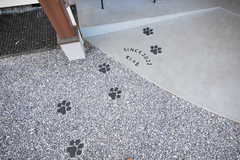 ペットの足跡が可愛らしいエントランス。素材選びとデザインに工夫が施されている。