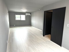 壁や床がモノトーン調で統一されたモダンな雰囲気な居室スペース。窓からの自然光が明るい空間を演出している。【建築システム（狭小住宅専門店）】