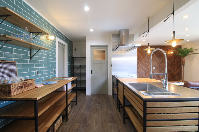 木とアイアンを使ったカウンターに、スモーキーブルーのタイルが映えるキッチン