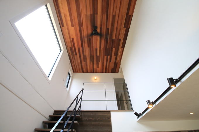 吹き抜けのリビングは、大きな窓から柔らかな光が降り注ぎ、さらにシーリングファンがリゾート感を演出