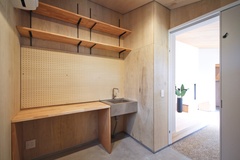 玄関土間。シンプルながらも機能的なデザインが魅力的である。棚も設置されており、収納スペースも確保されている。