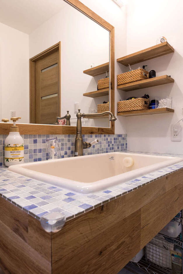 造作洗面台はモザイクタイルを貼って実用性とインテリア性を両立。アンティーク調の水栓のセレクトにセンスを感じる