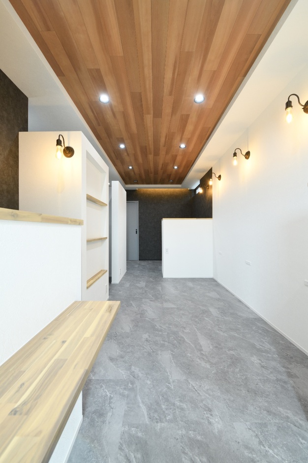 モダンで広々とした店舗スペース。天井には木目があしらわれ、落ち着いた雰囲気を醸し出している。