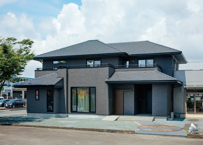 エフエフ住宅【掛川市細田293・モデルハウス】外回りも全面的に手が加えられ、タイル張りに。やや年月を感じさせていた表情から、重厚で飽きのこない姿へと生まれ変わった。子世帯用の玄関は、親世帯の玄関右手の奥まった場所にレイアウト。屋根のあるポーチ部分は、駐輪場や宅配ボックスの設置場所としても活躍する。同じ敷地内に、ヒノキの香りとハイブリッドソーラーシステムの心地よさで満たされた「ひのきの家」、子育て世代の“ほしい”を詰め込んだスタイリッシュモデル「NEWURBAN」という2棟の展示場も並ぶ。素材や間取り、家事ラクの参考に、あわせて見学するのもおすすめだ